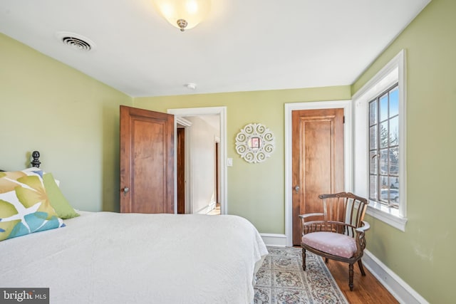 bedroom featuring hardwood / wood-style floors and multiple windows