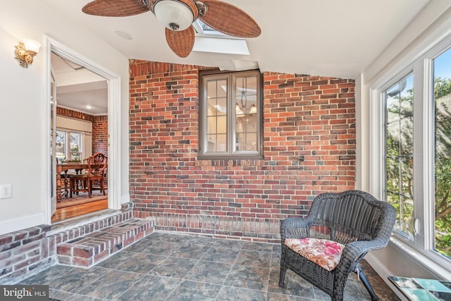 sunroom / solarium with a skylight, a wealth of natural light, and ceiling fan