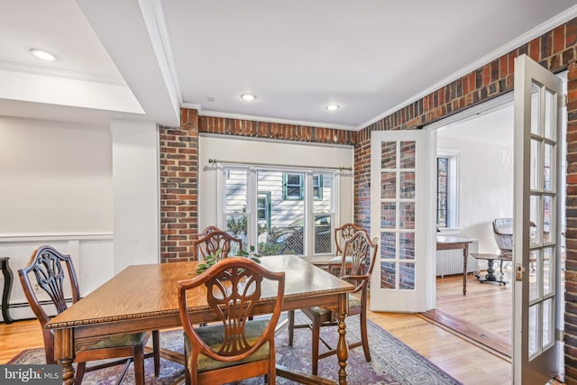 dining room featuring french doors, light hardwood / wood-style flooring, baseboard heating, and crown molding