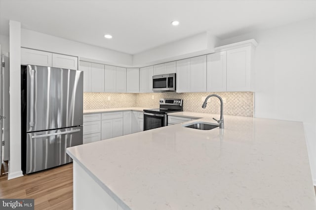 kitchen featuring white cabinetry, sink, light wood-type flooring, and appliances with stainless steel finishes