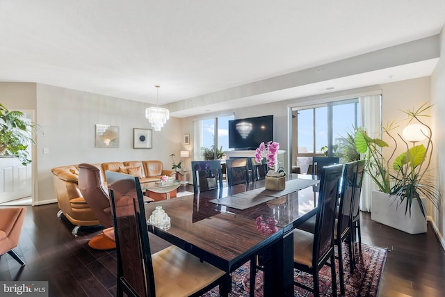 dining room with dark hardwood / wood-style flooring, an inviting chandelier, and a wealth of natural light