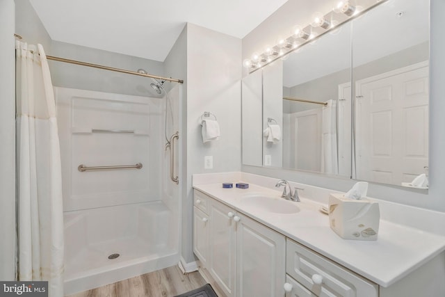 bathroom with wood-type flooring, vanity, and a shower with curtain