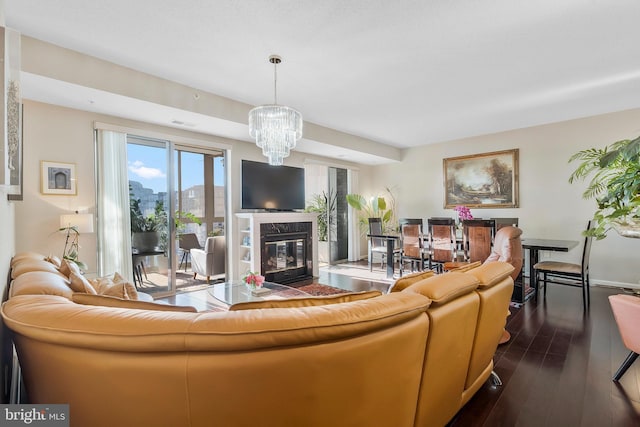 living room featuring a notable chandelier, dark hardwood / wood-style floors, and a premium fireplace