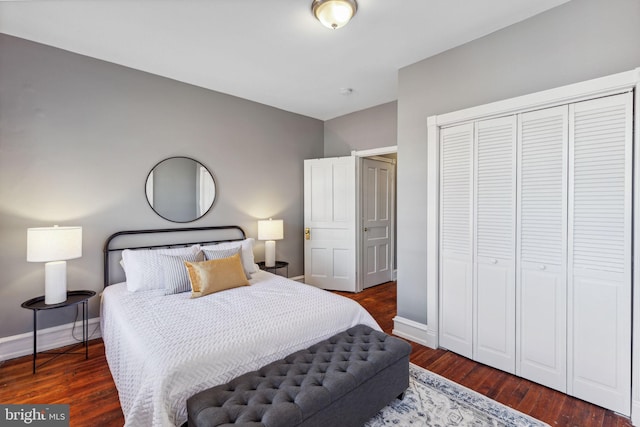 bedroom with dark hardwood / wood-style flooring and a closet