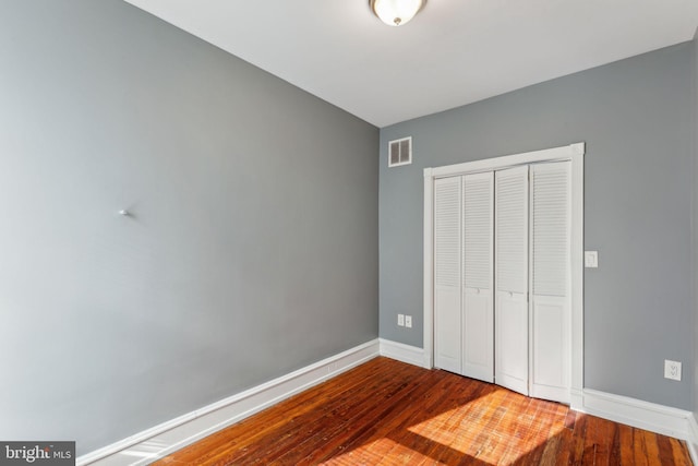 unfurnished bedroom featuring wood-type flooring and a closet