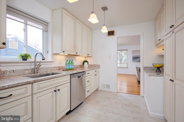 kitchen with white cabinetry, sink, light hardwood / wood-style flooring, stainless steel dishwasher, and pendant lighting