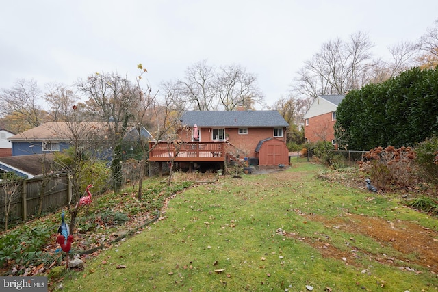 rear view of house featuring a lawn, a storage unit, and a wooden deck