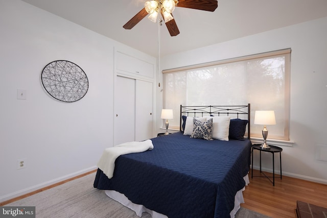 bedroom featuring ceiling fan, wood-type flooring, and a closet