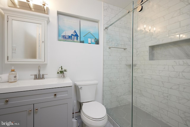 bathroom featuring tiled shower, vanity, and toilet