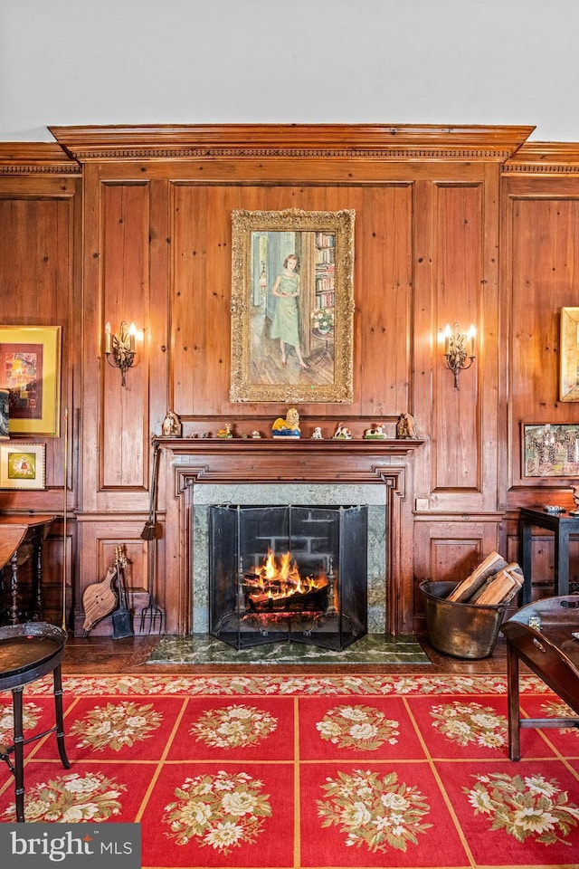 sitting room featuring wooden walls and a high end fireplace