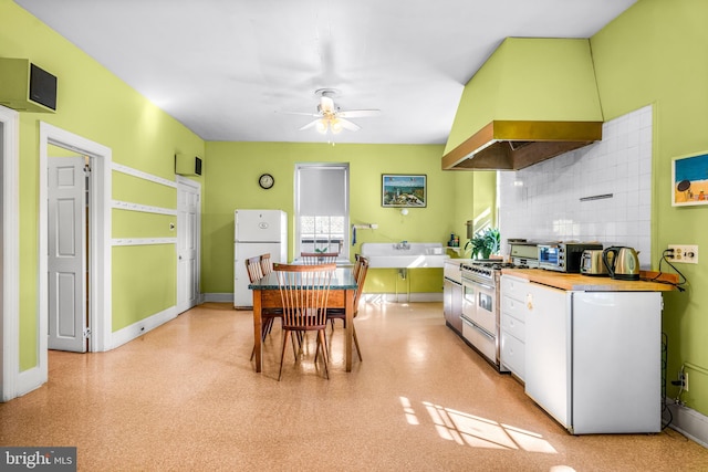 kitchen with high end range, backsplash, white cabinetry, exhaust hood, and white fridge