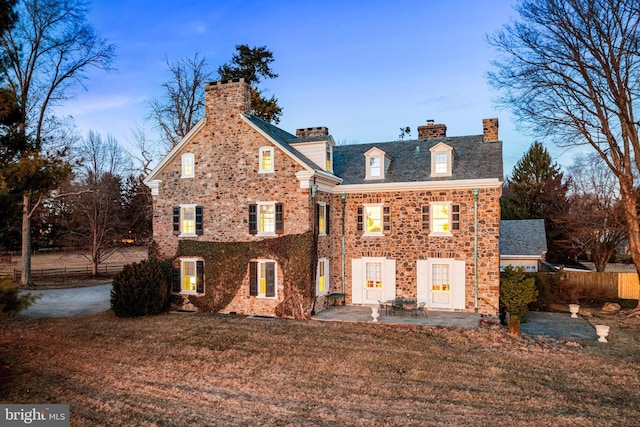 rear view of property featuring a yard and a patio area