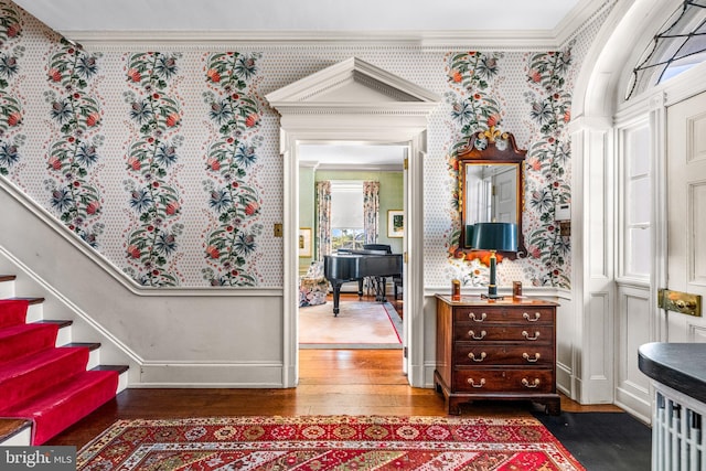 foyer entrance with crown molding and dark hardwood / wood-style floors