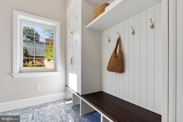 mudroom with dark tile patterned flooring