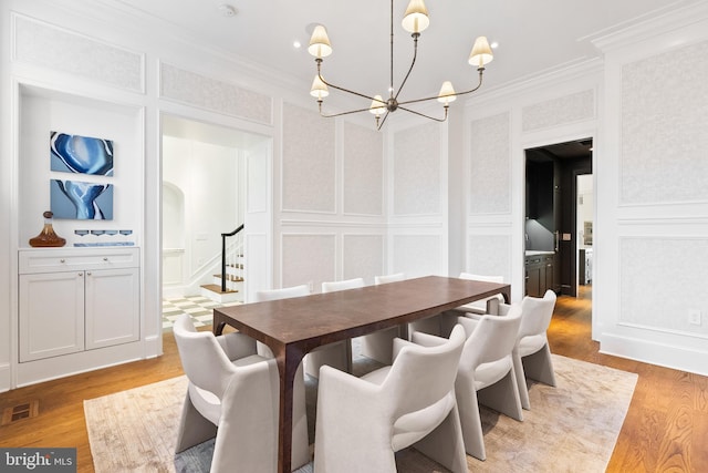 1524 33rd St NW, Washington, DC 20007 - dining space with a decorative wall, a chandelier, light wood-type flooring, stairs, and ornamental molding
