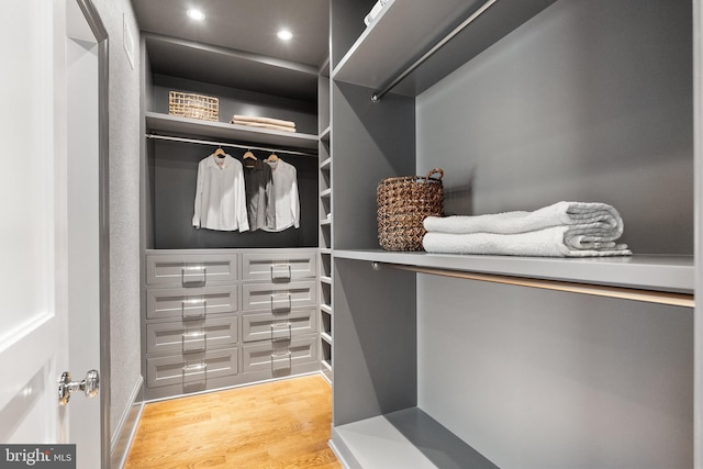 walk in closet with light hardwood / wood-style floors