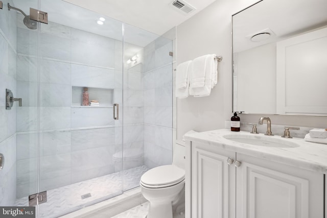 bathroom featuring vanity, toilet, and walk in shower