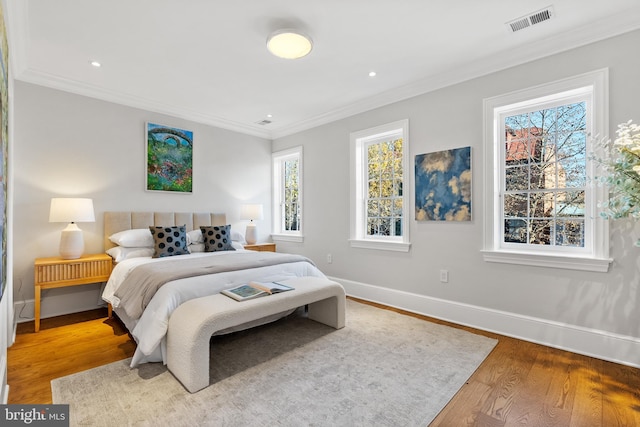 bedroom with hardwood / wood-style floors and crown molding