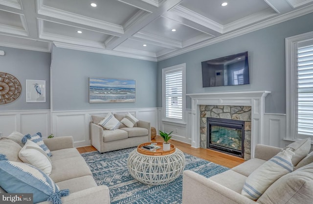 living room featuring hardwood / wood-style floors, coffered ceiling, crown molding, a fireplace, and beamed ceiling