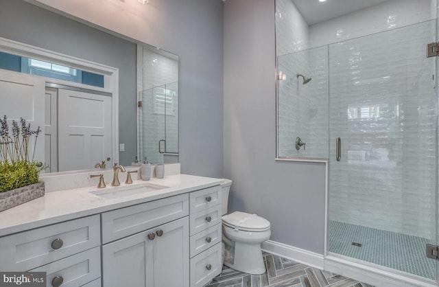 bathroom featuring vanity, toilet, and an enclosed shower