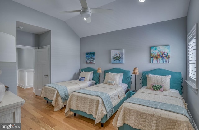 bedroom with multiple windows, ceiling fan, light hardwood / wood-style floors, and lofted ceiling