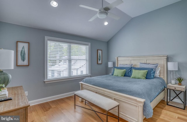 bedroom with ceiling fan, light hardwood / wood-style floors, and lofted ceiling