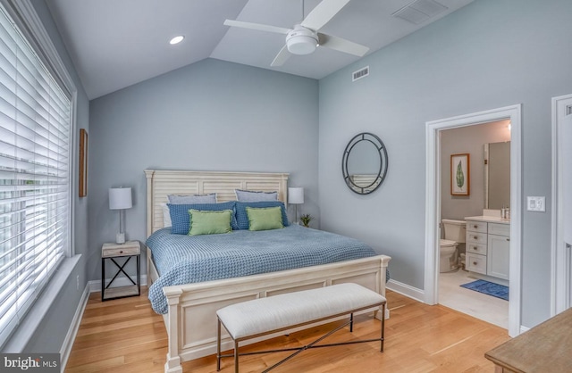 bedroom with vaulted ceiling, light hardwood / wood-style floors, ensuite bath, and ceiling fan