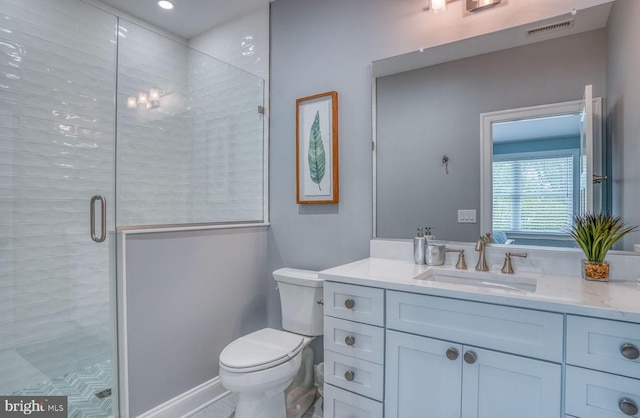 bathroom featuring vanity, toilet, and a shower with shower door