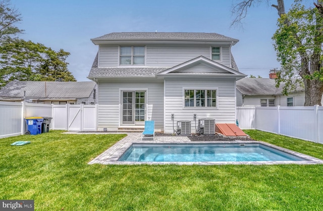 rear view of house with a lawn and cooling unit