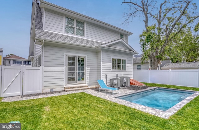 rear view of house featuring a yard, a patio, and central AC unit