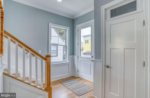 foyer featuring crown molding and light hardwood / wood-style floors