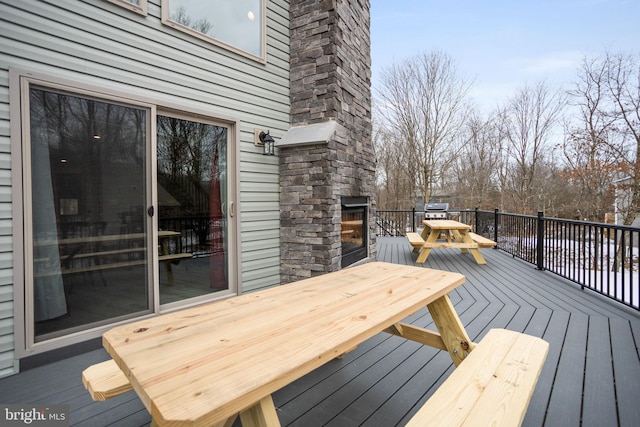 deck with an outdoor stone fireplace