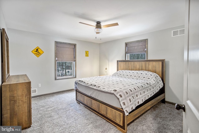 bedroom featuring ceiling fan, multiple windows, and carpet floors