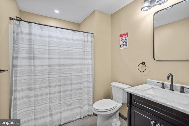 bathroom featuring vanity, wood-type flooring, and toilet