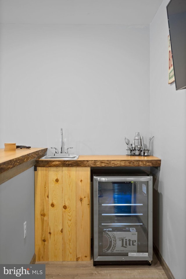 bar with wine cooler, sink, and wood-type flooring