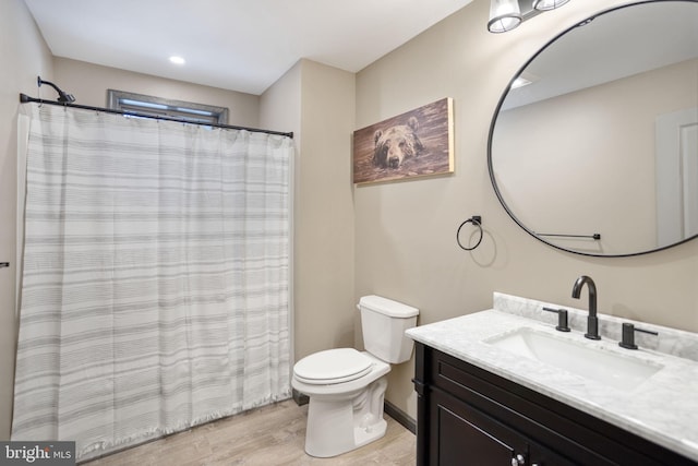 bathroom with vanity, hardwood / wood-style flooring, and toilet