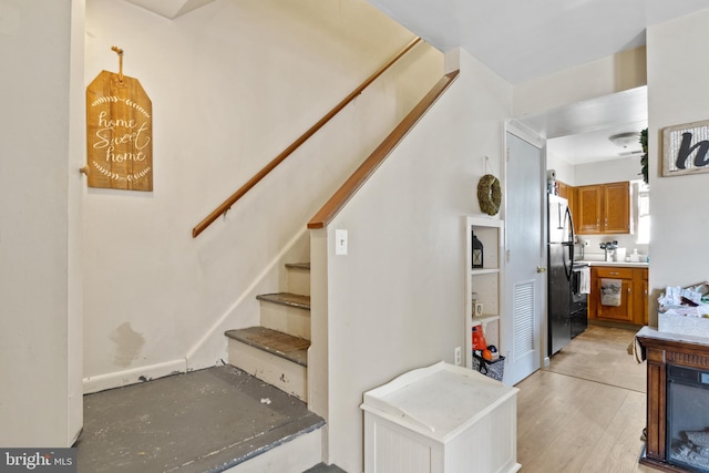 staircase featuring hardwood / wood-style floors and ceiling fan