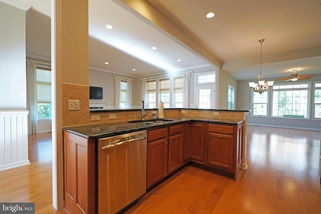 kitchen featuring dark stone counters, backsplash, a healthy amount of sunlight, and stainless steel dishwasher