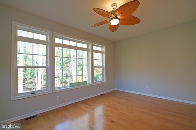 spare room featuring light hardwood / wood-style flooring, ceiling fan, and a healthy amount of sunlight