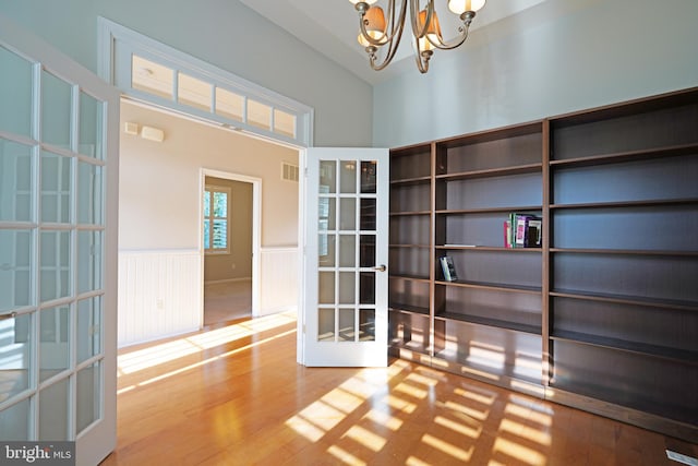 interior space with french doors, a chandelier, and hardwood / wood-style flooring