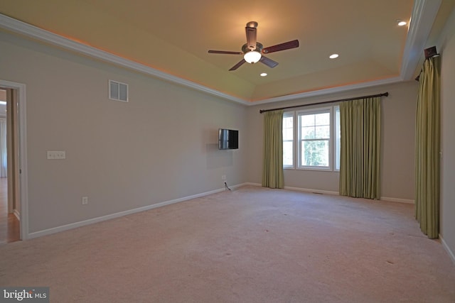 carpeted empty room featuring a tray ceiling, ceiling fan, and ornamental molding