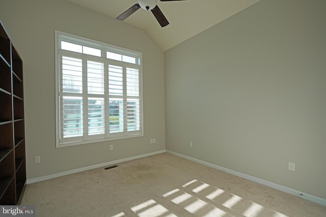 carpeted empty room featuring a wealth of natural light, ceiling fan, and lofted ceiling