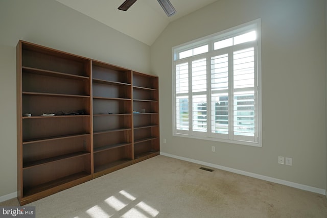 carpeted spare room featuring ceiling fan and vaulted ceiling