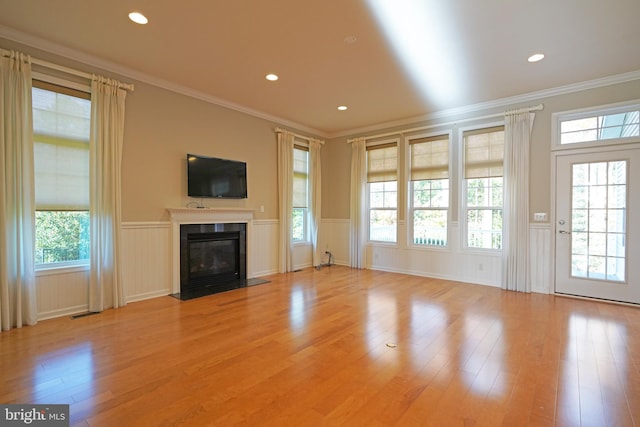 unfurnished living room featuring ornamental molding, light hardwood / wood-style floors, and a healthy amount of sunlight