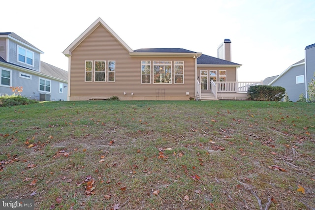 rear view of property featuring a lawn and a wooden deck