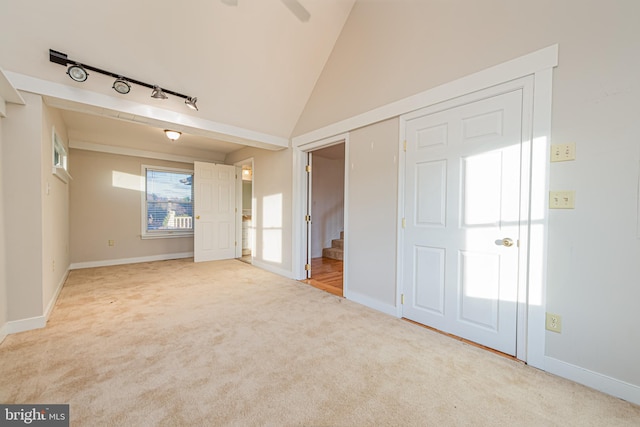 carpeted spare room featuring ceiling fan and lofted ceiling