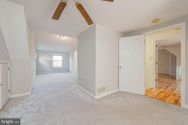 spare room featuring light hardwood / wood-style floors, vaulted ceiling, and ceiling fan