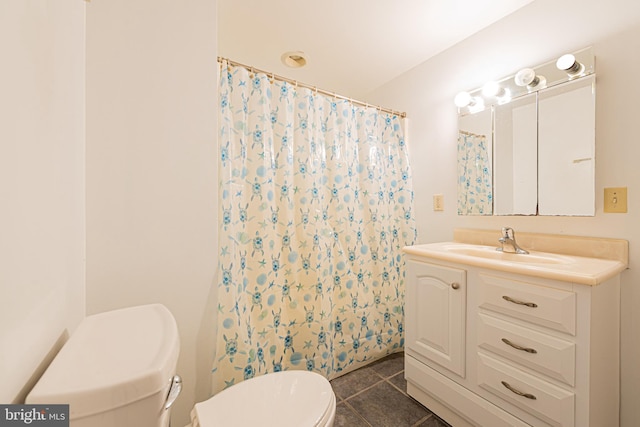 bathroom featuring tile patterned flooring, vanity, toilet, and walk in shower