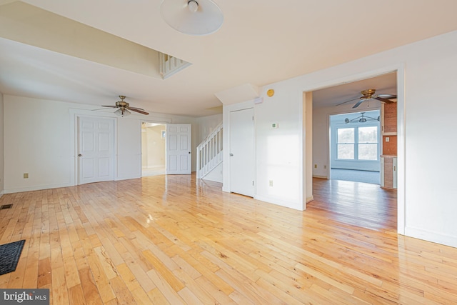 empty room with ceiling fan and light hardwood / wood-style floors