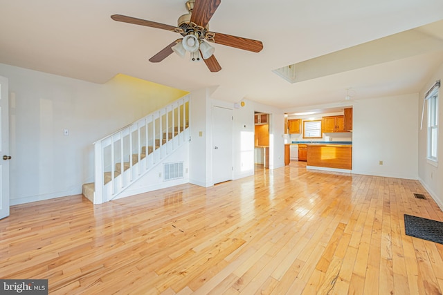 unfurnished living room featuring light wood-type flooring and ceiling fan